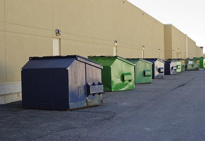 a yellow construction dumpster filled with waste materials in Maywood